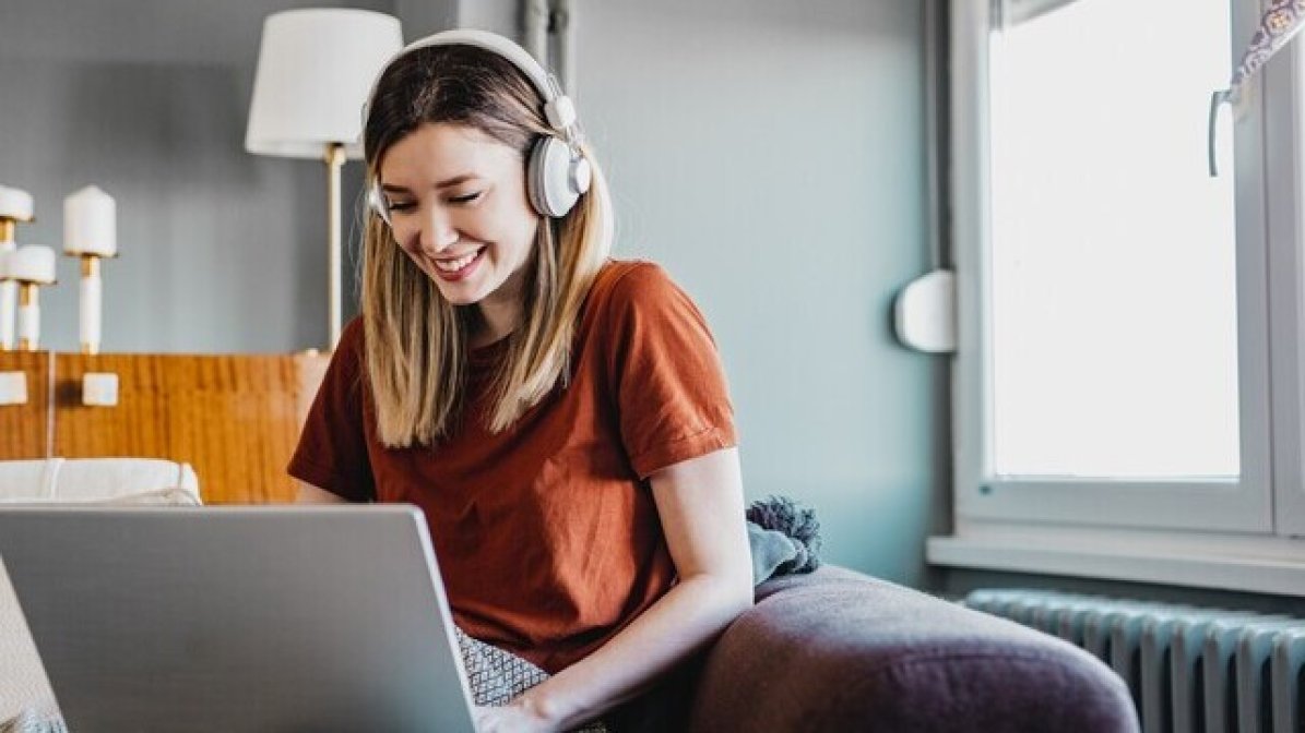 Young woman with headphones on laptop