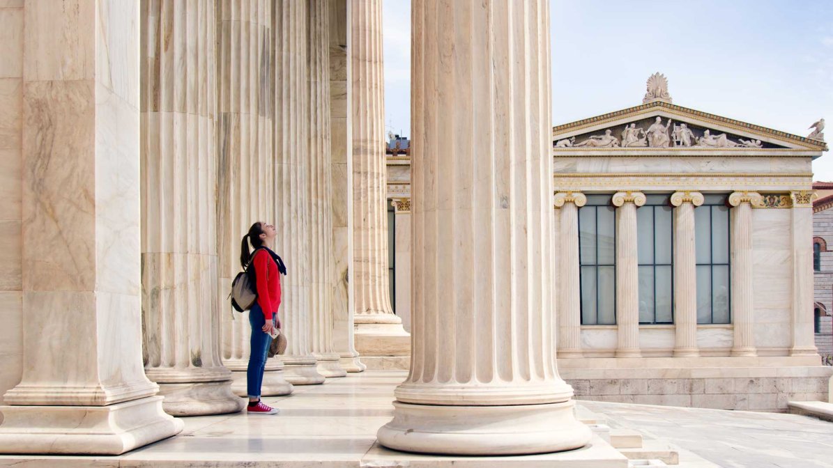 Woman looking up at ancient architecture